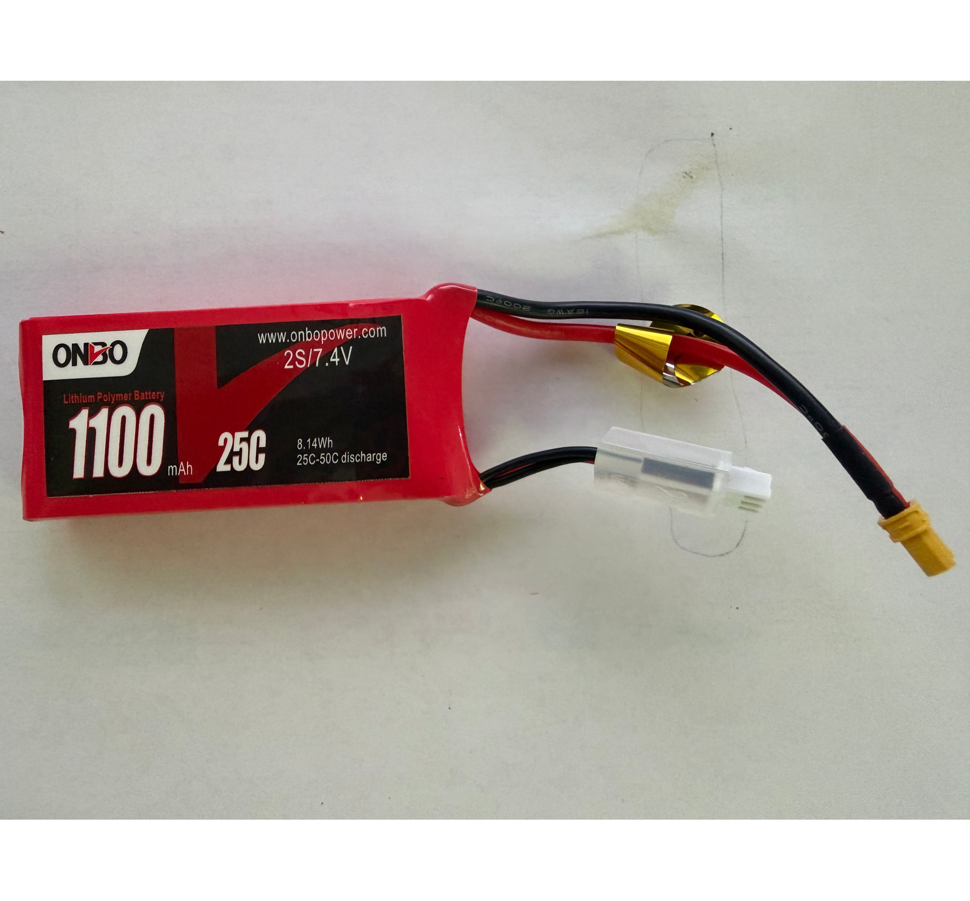 A red ON10 1100mAh 25C lithium polymer (LiPo) battery with black and red wires, gold connectors, and a white JST connector, shown on a plain off-white background.
